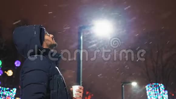 戴眼镜的印度男人在公园的傍晚看飞雪视频的预览图