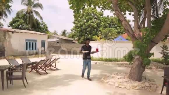 马尔代夫丹盖提岛的户外餐厅年轻的侍者端着食物食物和饮料的概念视频的预览图