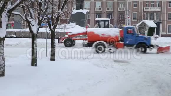 挖掘机清扫城市大量积雪的街道视频的预览图