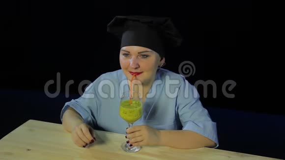 女人在黑色背景下烹饪品尝水果冰沙并显示标志OK视频的预览图