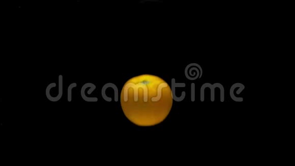 一个黄色的番茄落在黑色背景上的透明水中视频的预览图