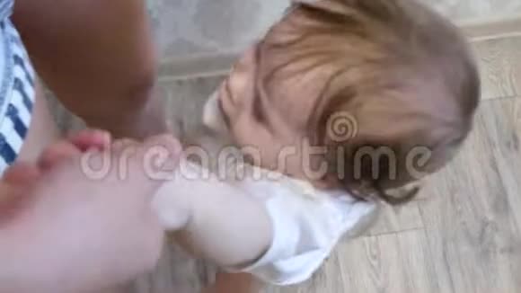 一个小婴儿牵着妈妈的手跳着笑视频的预览图