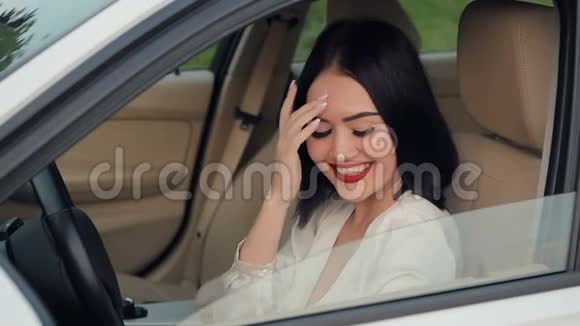 一幅美丽快乐的女人坐在车里对着镜头调情的肖像在交通堵塞中和另一个汽车司机交谈慢慢视频的预览图
