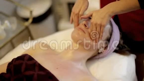 美容水疗沙龙面部按摩女性在美容水疗中心享受放松的面部按摩视频的预览图