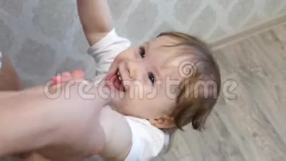 小宝宝跳到地板上和妈妈牵着手在他的托儿所里笑视频的预览图