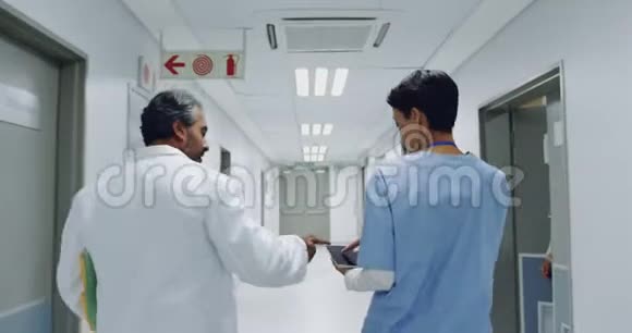 两名医生在医院走廊散步交谈4k视频的预览图