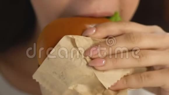 享受油腻汉堡垃圾食品卡路里和饱和脂肪的女人视频的预览图