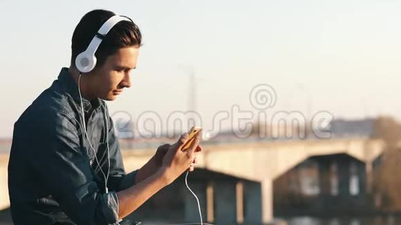 亚洲混血黑发少女带着耳机在户外听音乐视频的预览图