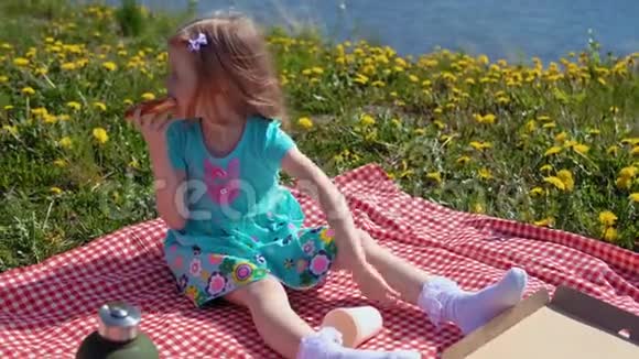 小金发女孩在温暖的一天在海滨吃披萨视频的预览图