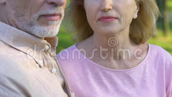 幸福微笑的老妇人把头靠在老人的肩膀上慢动作视频的预览图