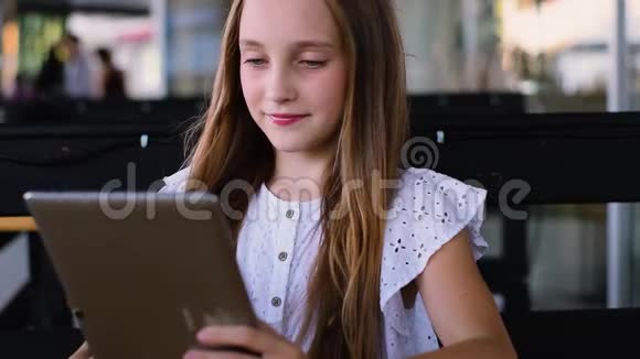 小女孩在咖啡馆里用平板电脑玩游戏视频的预览图