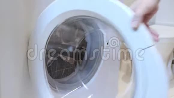 女人把脏衣服放进洗衣机把它关上视频的预览图