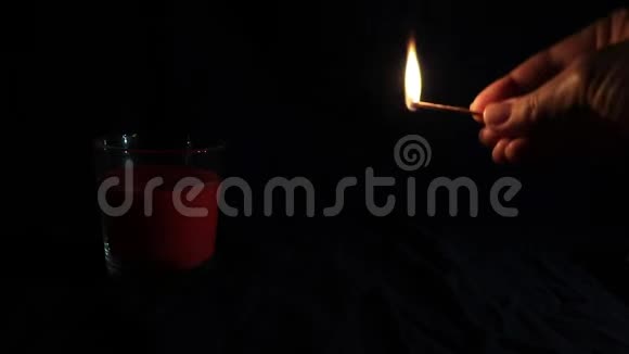 用闪烁的火焰点燃红烛用手点燃一根与复制空间相匹配的暗底蜡烛视频的预览图