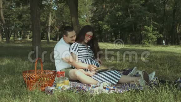 快乐的怀孕家庭在夏季公园休息视频的预览图