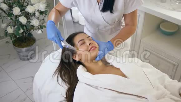 在美容院的治疗室借助脉动的氧气压力进行皮肤护理程序的快乐病人女孩视频的预览图
