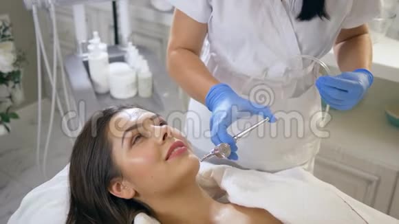 护肤面部放松女性患者的美容程序刺激美容院的更新过程视频的预览图