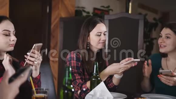 女孩的披萨照片在你的智能手机上餐厅里欢快女孩的陪伴女孩子喜欢喝酒视频的预览图