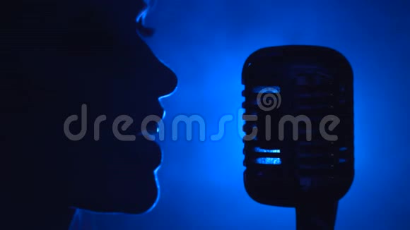 歌手用复古麦克风唱歌烟雾背景剪影侧视关门视频的预览图