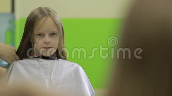 发型师在理发店剪可爱女孩的头发视频的预览图
