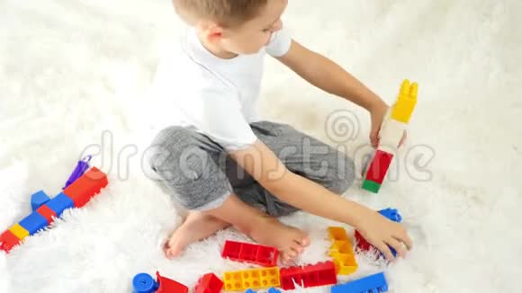 一个孩子在白色背景上玩彩色积木快乐男孩在玩儿童发展的概念视频的预览图