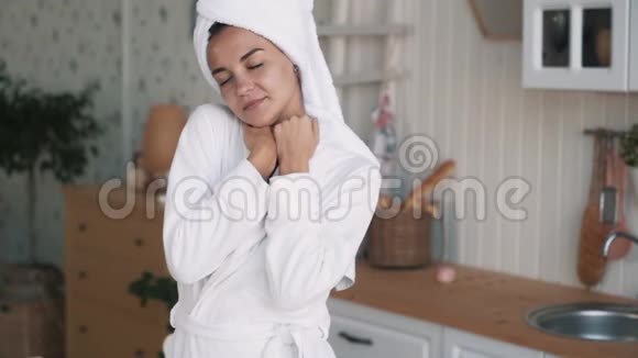穿着浴袍头上戴毛巾的女人看着镜头微笑慢动作视频的预览图