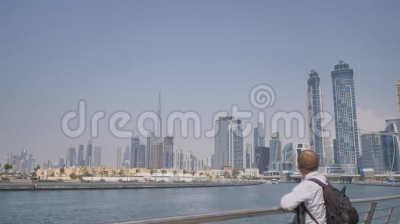 一个男人用迪拜希腊区的摩天大楼观看城市全景视频的预览图