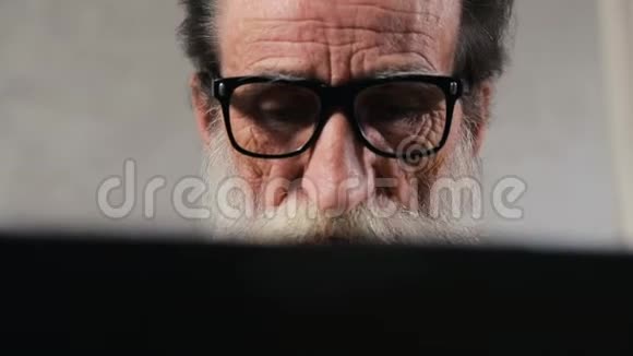 老人在笔记本电脑上阅读信息视频的预览图