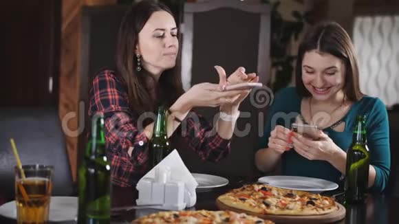 餐厅里欢快女孩的陪伴女孩们喜欢喝啤酒和吃披萨女孩的照片视频的预览图