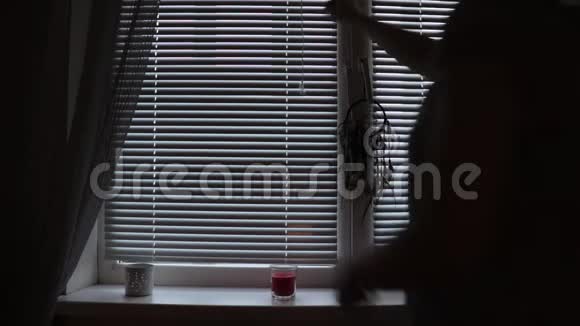 一个女人的剪影打开了贾洛西在家里的窗帘视频的预览图