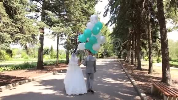 新婚快乐带着气球在公园里散步视频的预览图