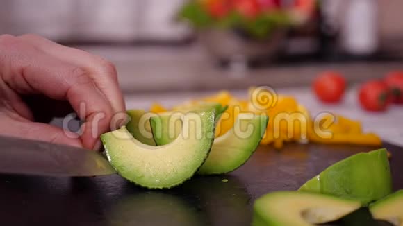 女人手剥牛油果切片慢动作视频的预览图