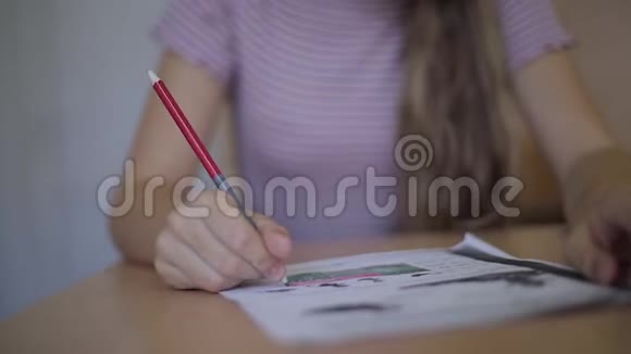 快乐的女学生坐在书桌上写作业本视频的预览图