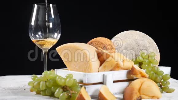 红酒倒在奶酪盘的背景上奶酪爱好者美味的硬奶酪配有精美的视频的预览图