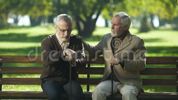 老人支持沮丧的朋友坐在养老院附近的公园里迷路了视频的预览图