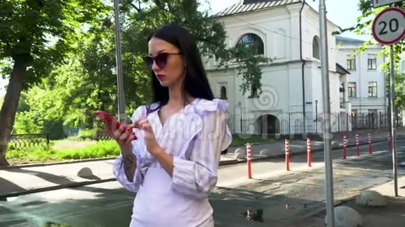 时尚女性在电话中拨打电话站在城市街道上开始交谈视频的预览图