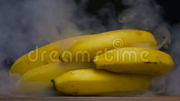 成熟的新鲜卡文迪什香蕉从后面被烟雾吹走关闭4K视频的预览图