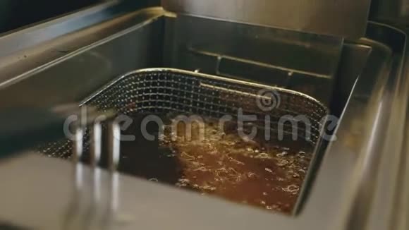 在一家汉堡店的厨房里在一个深油炸锅里煮油视频的预览图