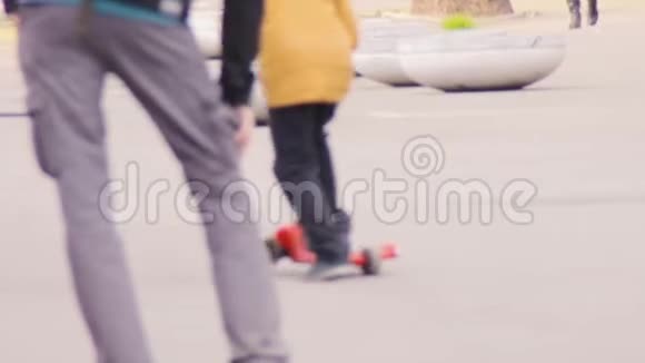 一个穿黄色夹克的小男孩骑着滑板车视频的预览图