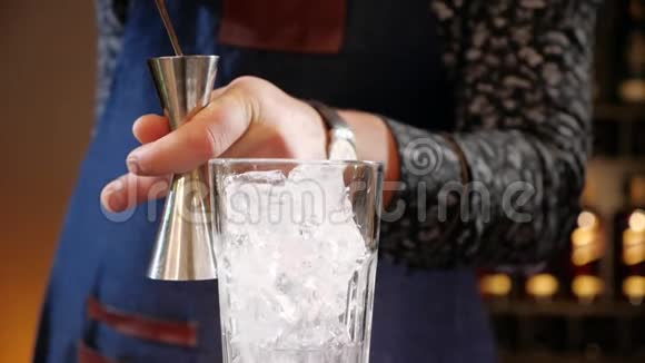 酒保双手用跳汰机测量鸡尾酒倒入玻璃杯视频的预览图