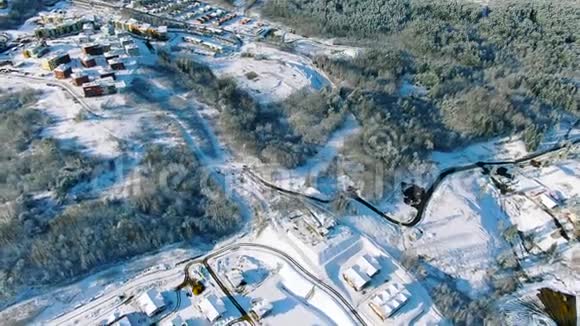 俄罗斯乡村郊区村庄的冬季景色雪覆盖的绿树和冰冻的绿色小湖视频的预览图