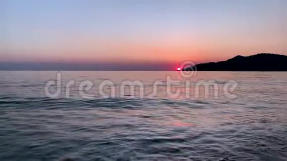 美丽的海上日落镜头海洋附近的山脉视频的预览图