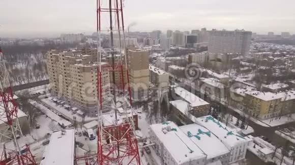 摄像机正沿着一座现代化的电信塔在城市建筑和道路上的鸟瞰视频的预览图