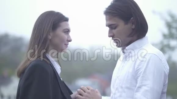 帅哥用呼吸温暖女性的双手户外男人和女朋友一起度过恋爱的时光视频的预览图