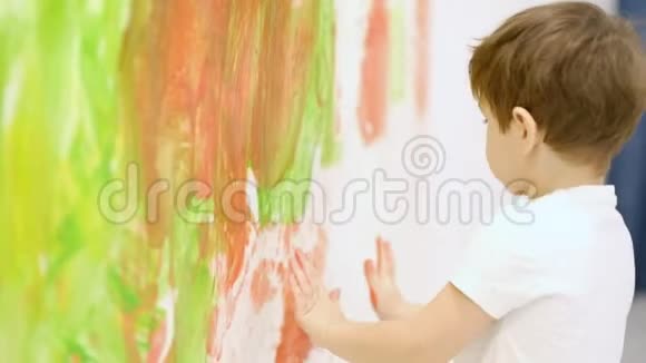 和妈妈一起在白色的墙上做彩色的手印把快乐的小孩子合上慢动作视频的预览图