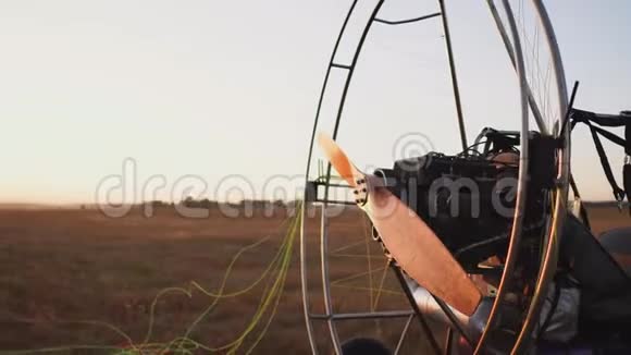 男子驾驶马达滑翔伞在野外日落时将降落伞固定在滑翔伞的身体上视频的预览图