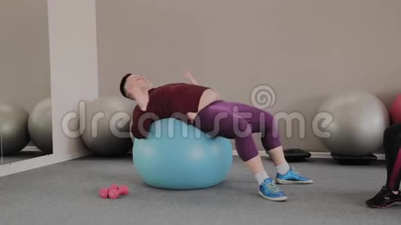 快乐的胖子在健身球上训练视频的预览图