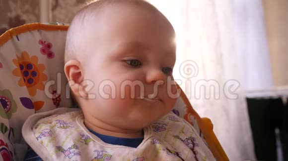 用勺子喂婴儿妈妈的手而小可爱的男孩看着周围的4K慢妈妈特写视频的预览图