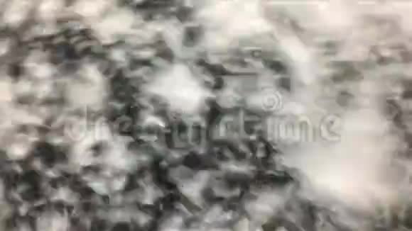 蓬松的人工雪花在黑色背景上旋转假蓬松的雪背景视频的预览图