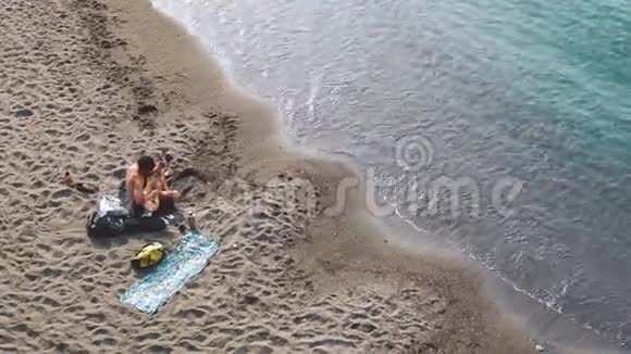 年轻夫妇在海滩上一起演奏音乐和唱歌视频的预览图