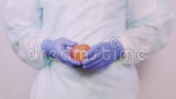 医生向病人伸出一个苹果双手戴医用手套特写视频的预览图